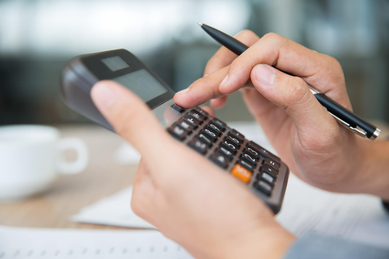 mano sosteniendo y utilizando calculadora