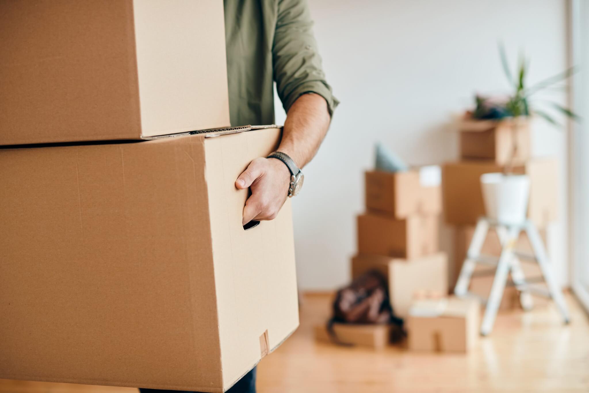 Primer plano de un hombre que lleva cajas de cartón
