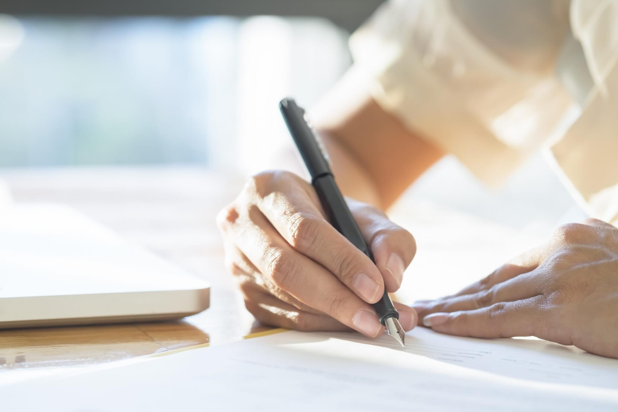 Mujer de negocios firmando un documento contractual haciendo un trato.